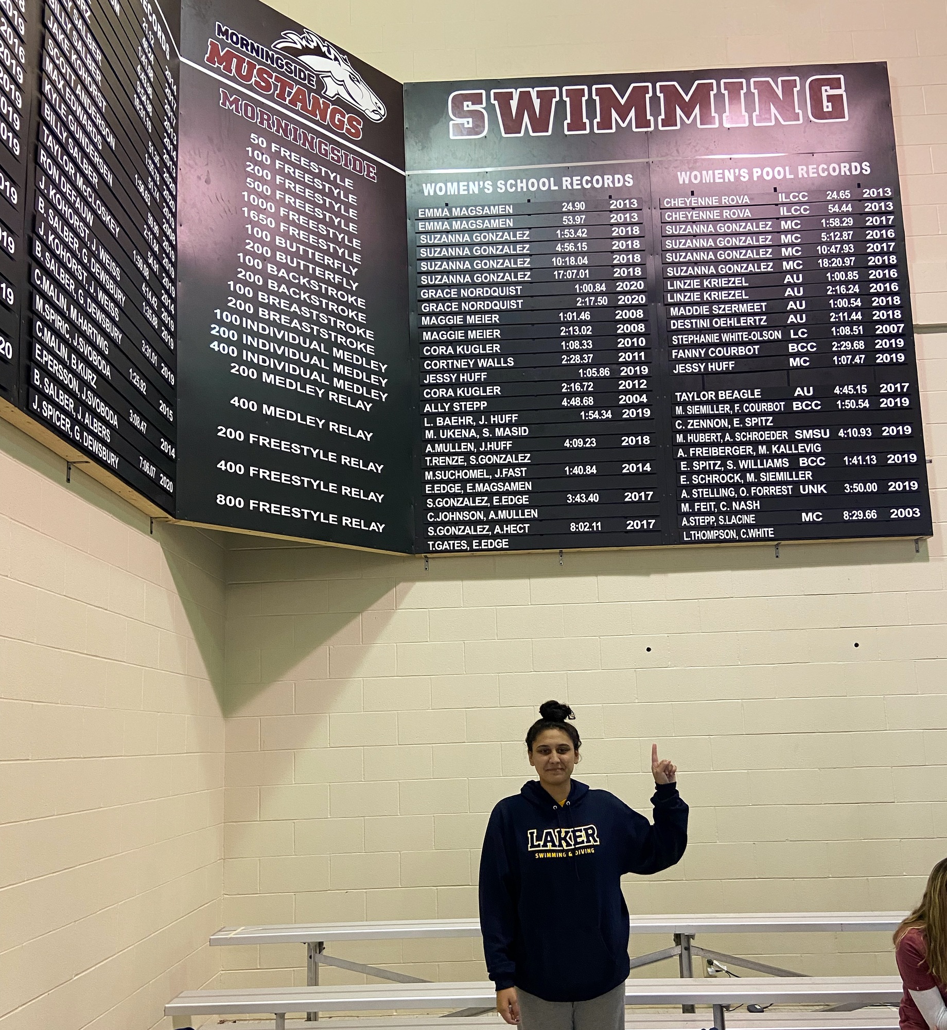 Moana Wind standing under Morningside University's pool record board.